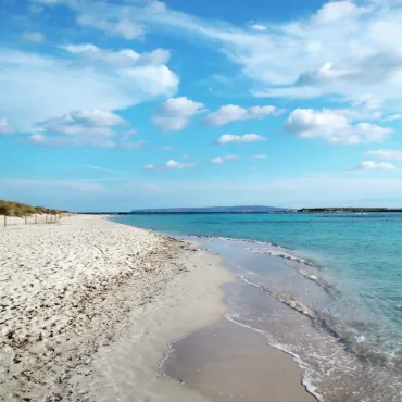 Biała piaszczysta plaża i turkusowa płytka woda przy wyspie Espalmador obok Formentery